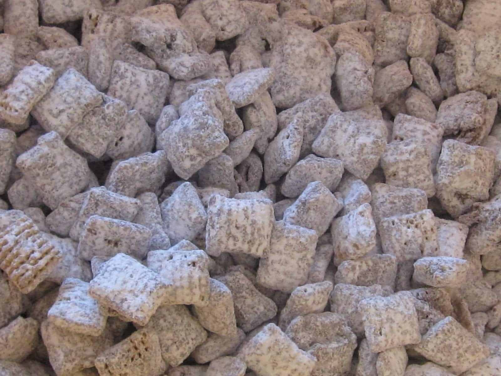 Close-up view of a batch of Muddy Buddies coated in powdered sugar