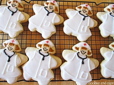 Overhead view of sugar cookies decorated as nurses on a cooling rack