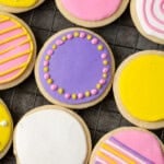 Overhead view of assorted round sugar cookies decorated with royal icing in different colors.