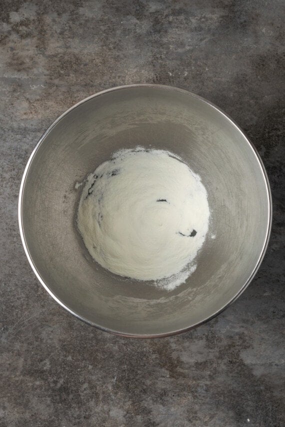 Water and meringue powder combined in a metal mixing bowl.