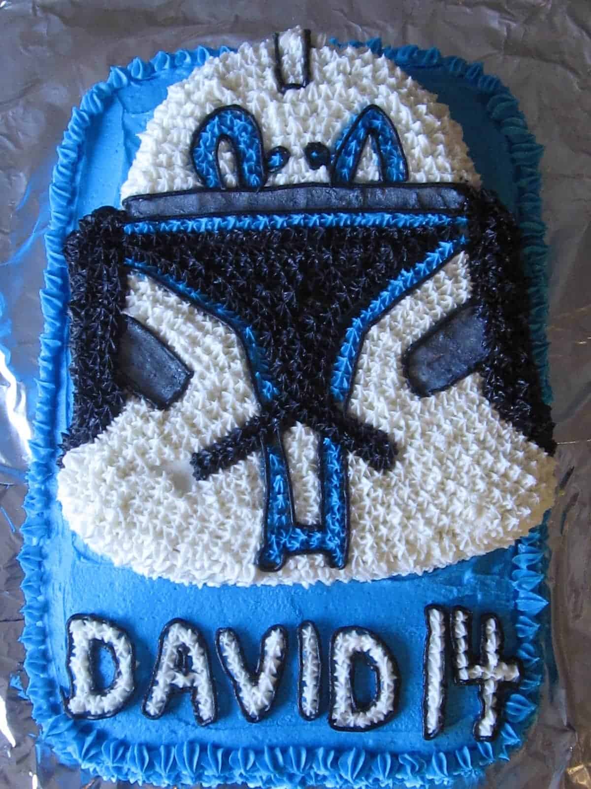 Overhead view of a Star Wars Clone Trooper mask birthday cake with David 14 text at the bottom