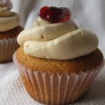 Side view of a Peanut Butter and Jelly cupcake with Peanut Butter frosting and a dollop of jelly on top