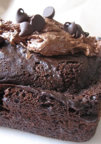 A Chocolate Overload Loaf Cake Topped with Chocolate Fluff Frosting and Chocolate Chips