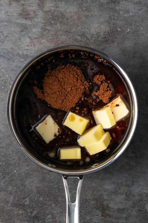 Butter, cocoa powder, and Coca Cola combined in a saucepan.
