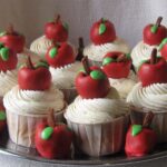 A tray of Teacher appreciation cupcakes with red oreo truffle apples on top