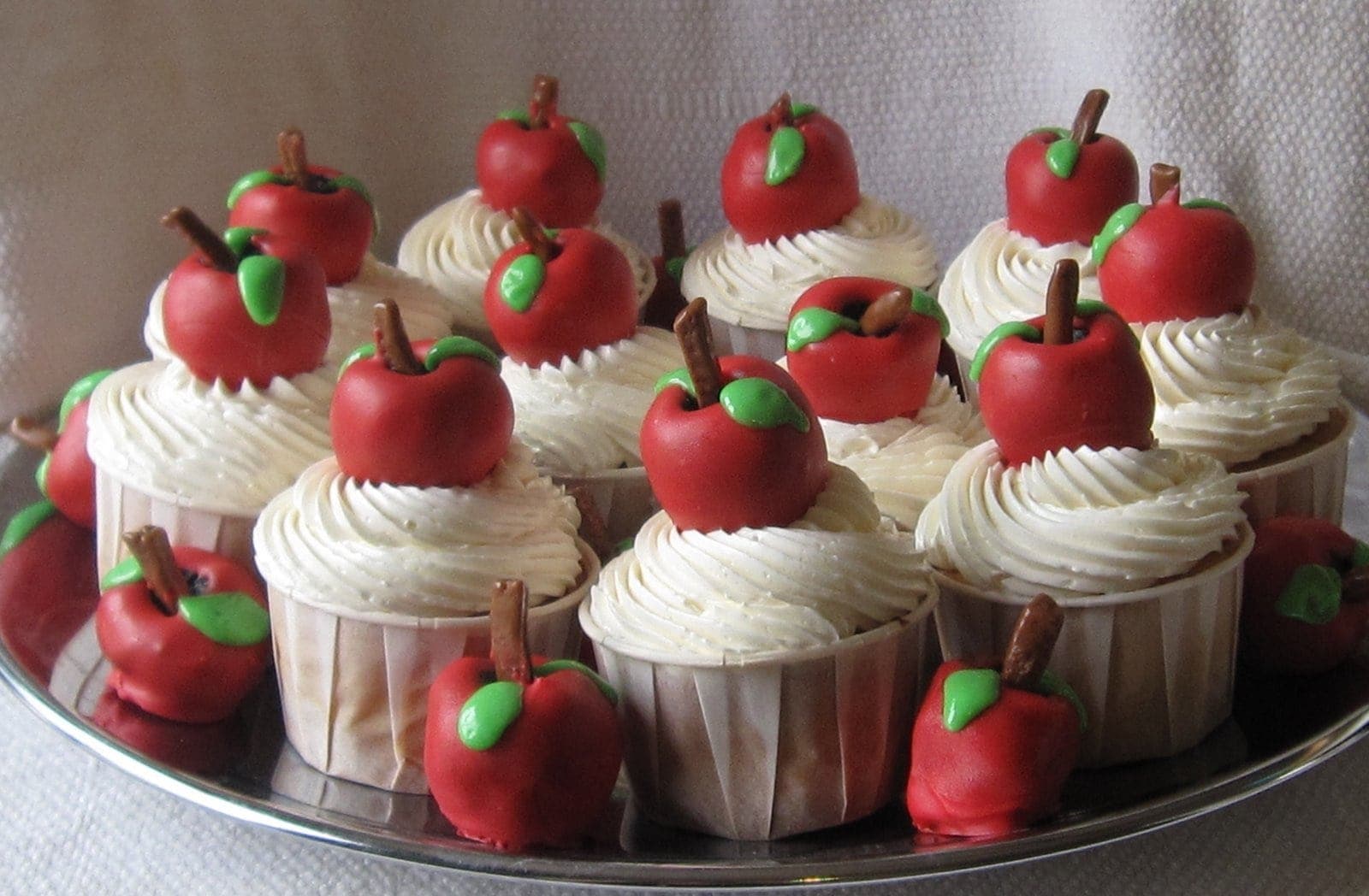 A tray of Teacher appreciation cupcakes with red oreo truffle apples on top