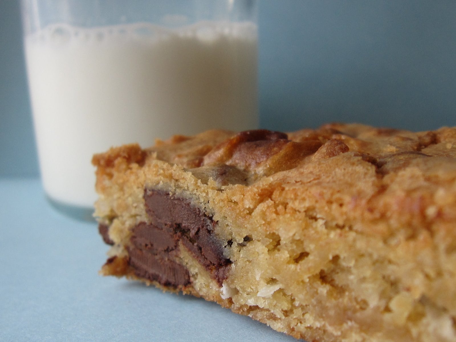 A chocolate chip blondie with a glass of milk