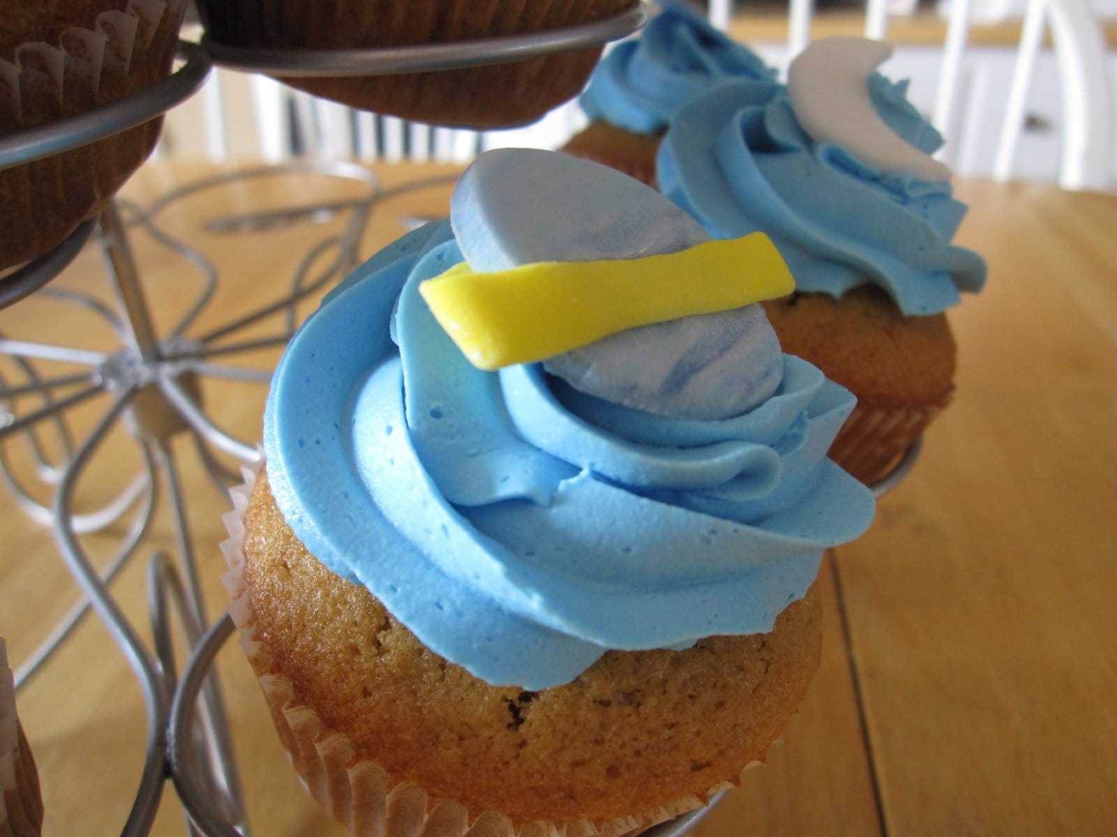 Close-up of a blue frosted cupcake with the planet Saturn on top