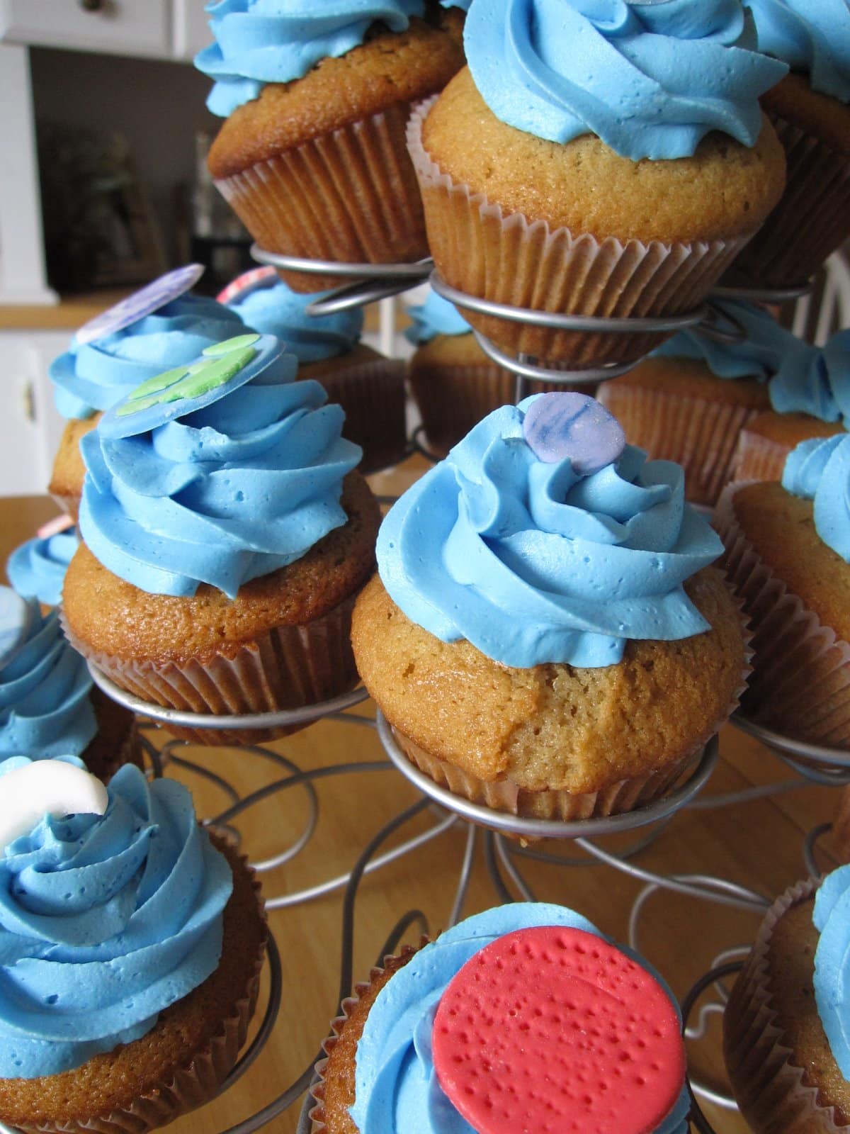 Several blue frosted cupcakes with planet decorations