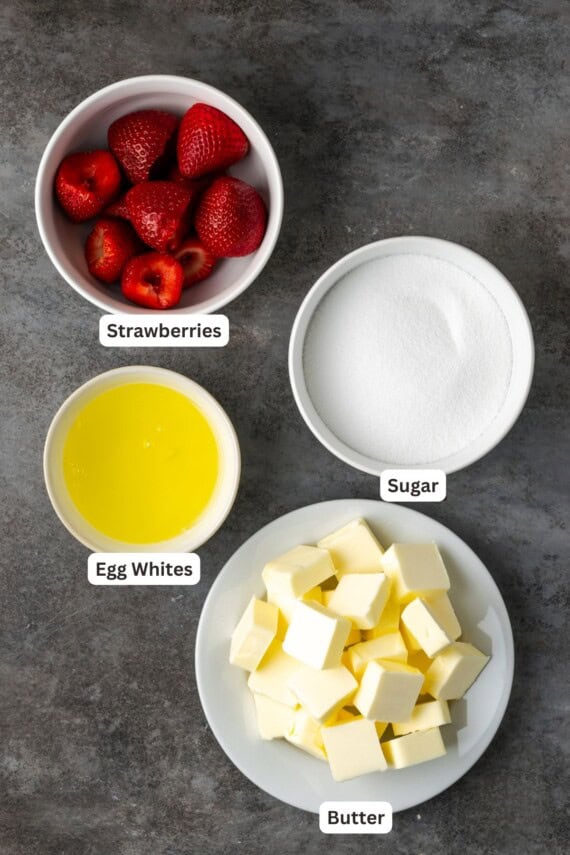 Ingredients for strawberry Swiss meringue buttercream frosting with text labels overlaying each ingredient.
