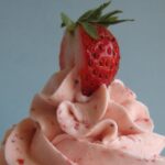 Close-up of strawberry frosting with a strawberry on top