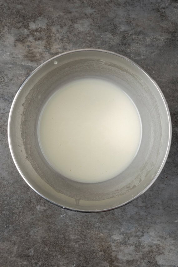 Sugar dissolved into egg whites in a metal bowl.