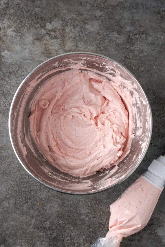 Strawberry Swiss meringue buttercream frosting in a metal bowl.