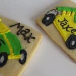 Overhead view of two personalized cookies with green and yellow race cars.