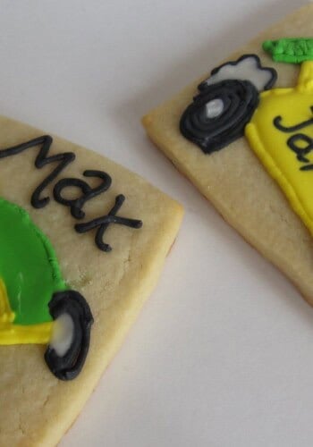 Overhead view of two personalized cookies with green and yellow race cars