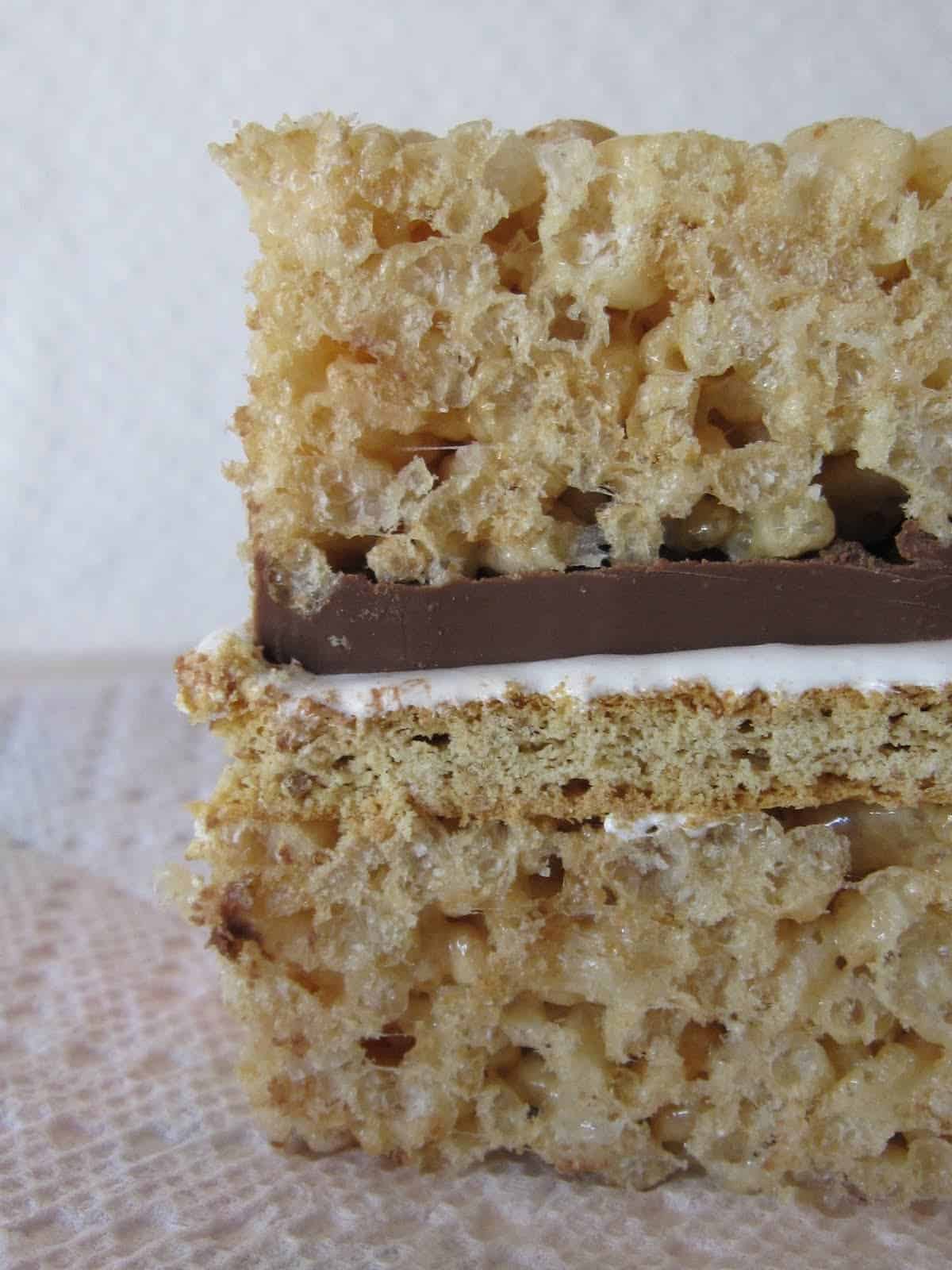 Side view of a S'Mores Krispie Treat with chocolate and marshmallow in the middle