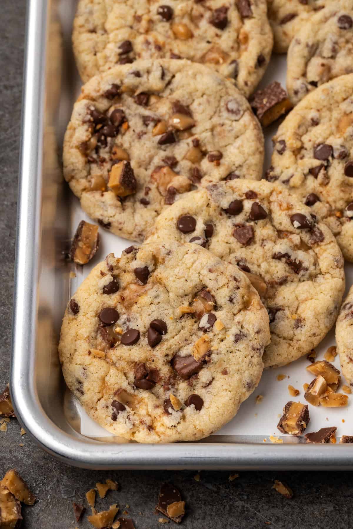 Overhead view of toffee chocolate chip cookies on a baking tray.