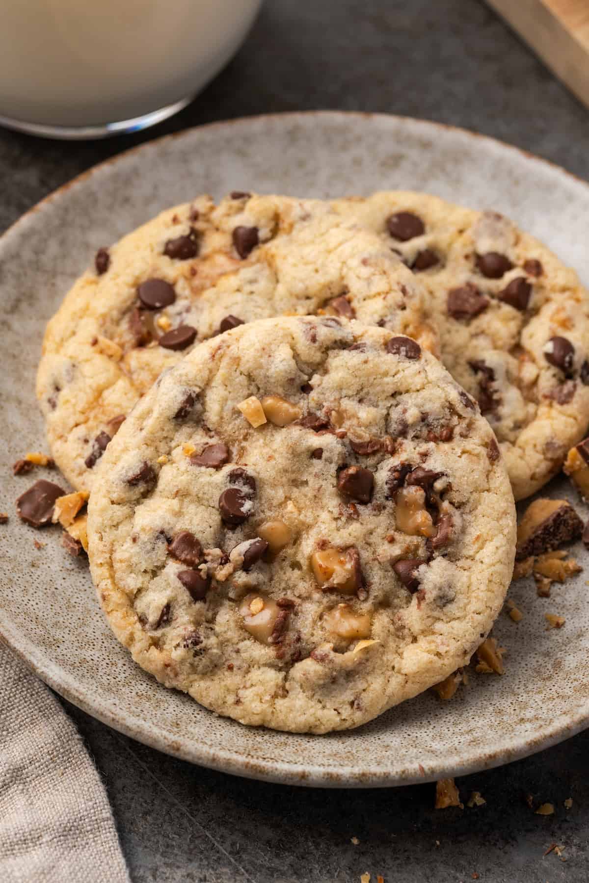 Close up of toffee chocolate chip cookies on a stoneware plate.
