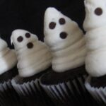 Close-up of chocolate cupcakes with vanilla frosting decorated like ghosts