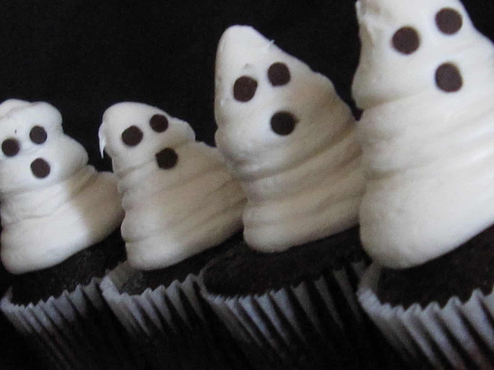 Close-up of chocolate cupcakes with vanilla frosting decorated like ghosts