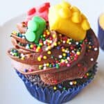 Close-up view of a cupcake with chocolate frosting and candy lego decorations