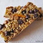 Overhead view of two homemade granola bars with chocolate chips and pretzels.
