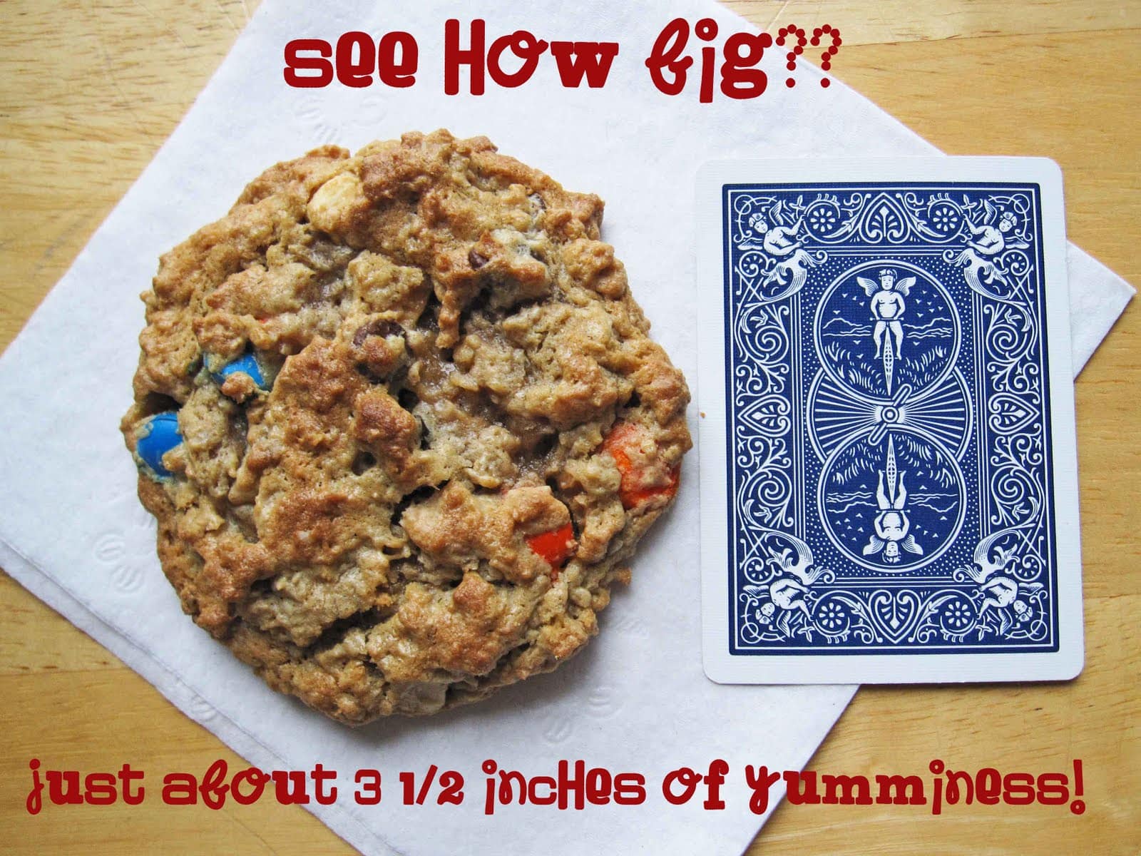 A monster cookie next to a playing card to show its size