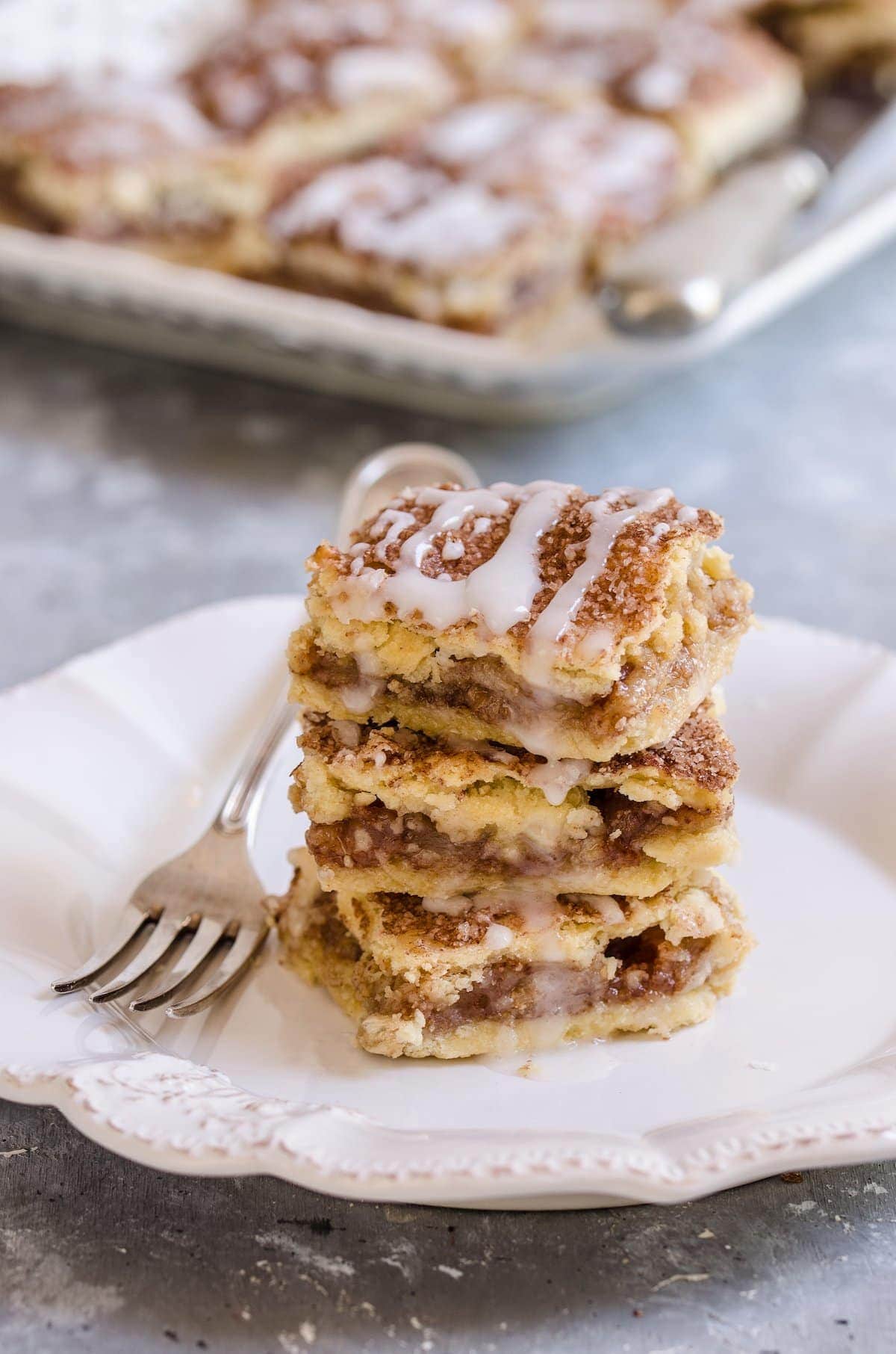 A stack of apple pie bars on a plate.