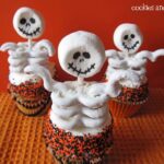Overhead view of 3 cupcakes with skeleton toppers