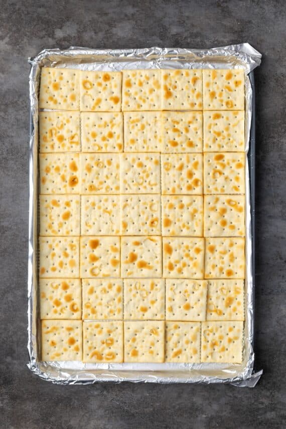 Saltine crackers arranged inside a baking pan.