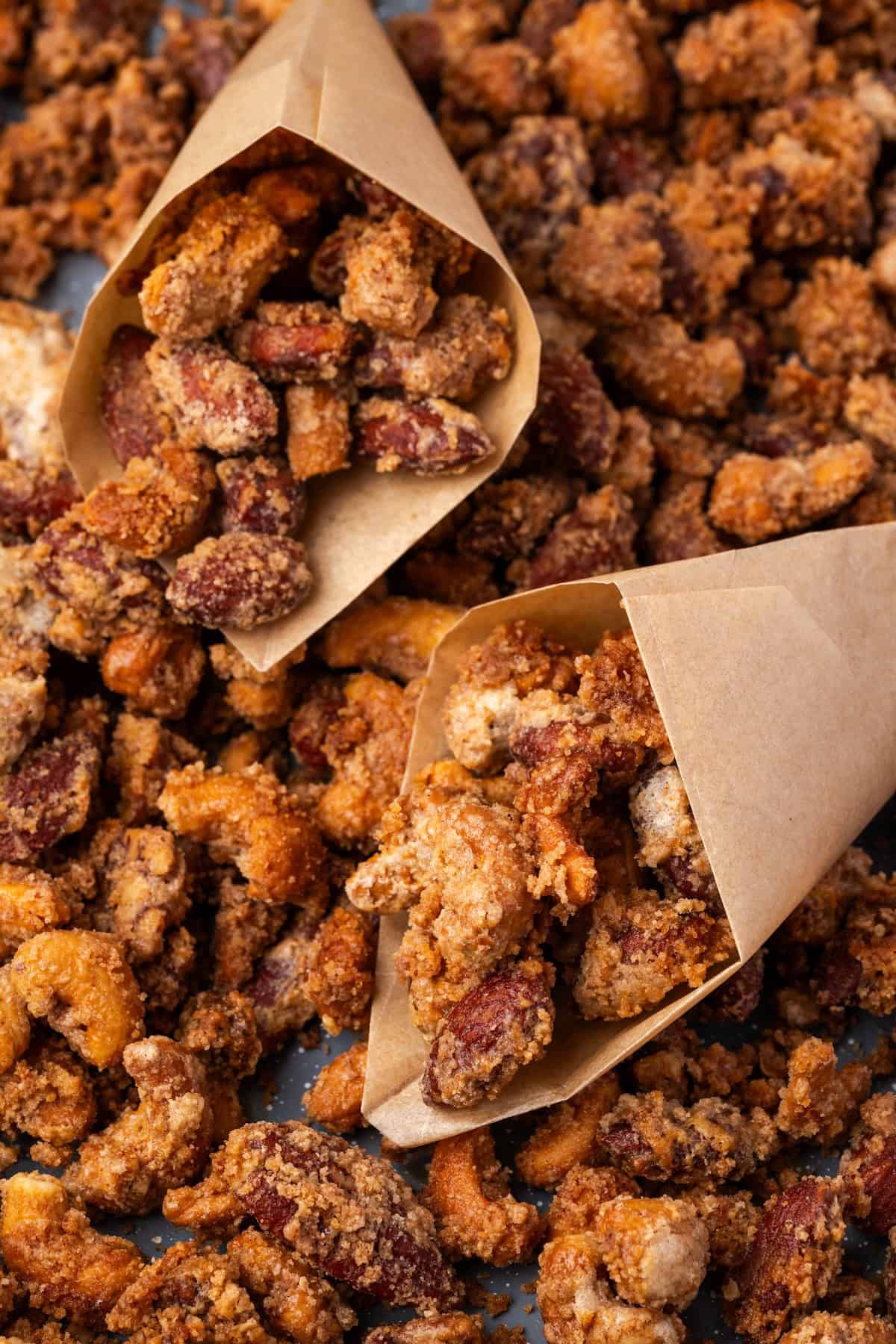 Two paper cones filled with mashuga nuts surrounded by more nuts.