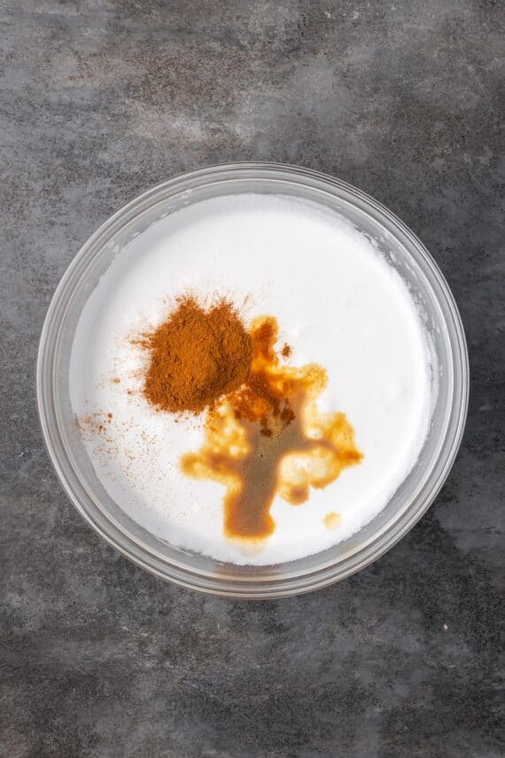 Cinnamon added to a bowl of meringue.