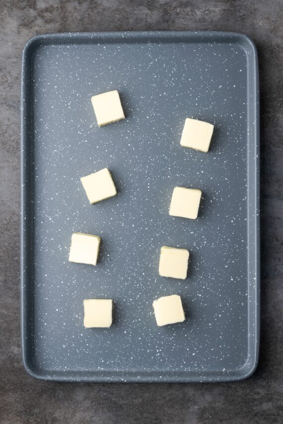 Pats of butter arranged on a baking sheet.
