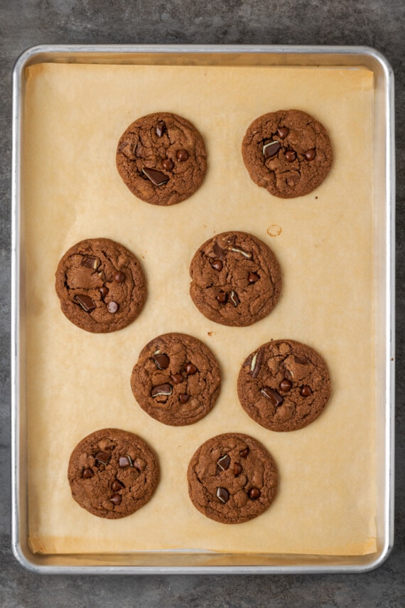 Baked double chocolate mint cookies on a parchment-lined baking sheet.