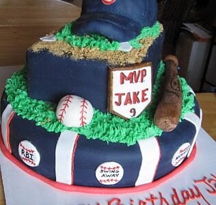 A navy multi-layer baseball themed cake with a hat on top