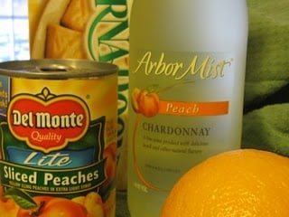 A can of peaches next to a bottle of Peach Chardonnay.