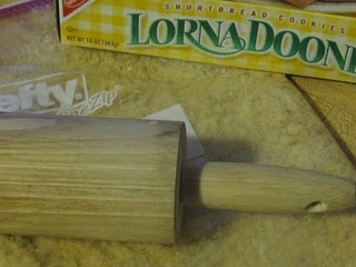 A wooden rolling pin next to a box of Lorna Doone shortbread cookies.