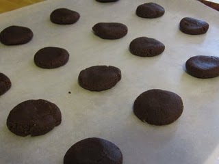 Chocolate cookies laid out on a parchment lined baking sheet.