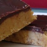 A Close-Up Shot of Two Chocolate Peanut Butter Dessert Bars on a Blue-Rimmed Plate