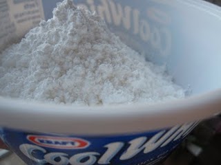 A plastic container full of powdered sugar.