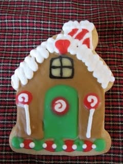 A Sugar Cookie with a Gingerbread House Decoration in Royal Icing