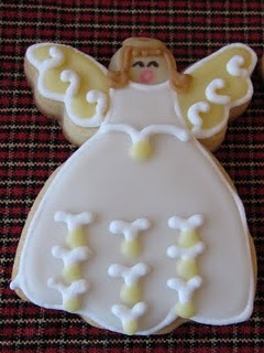 An Angel-Shaped Sugar Cookie with an Angel Decoration in Icing on Top