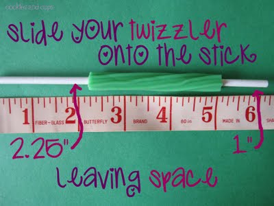 Green twizzler on a candy stick next to a ruler