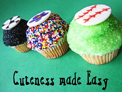 A line of three colorful decorated cupcakes with a green background