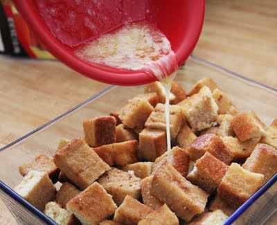 Melted butter being poured over French Toast pieces in a baking dish