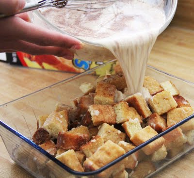 Milk and egg mixture being poured over French Toast pieces in a baking dish