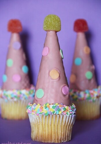 Close-up of three party hat cupcakes.