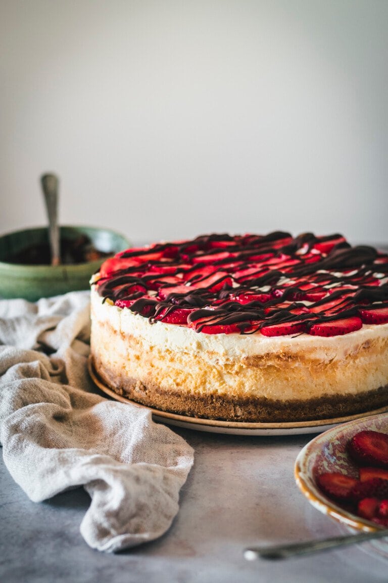 Chocolate covered strawberry cheesecake on a plate.