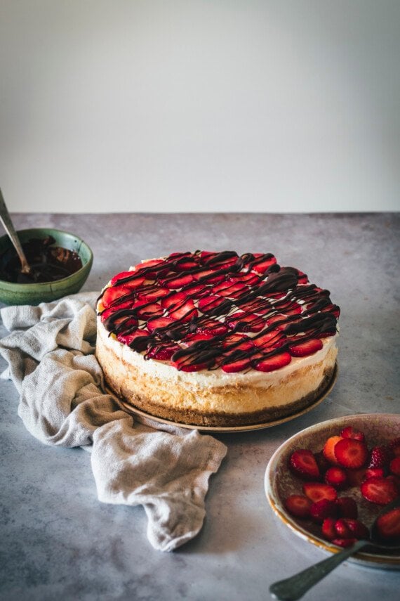 Chocolate covered strawberry cheesecake on a plate.