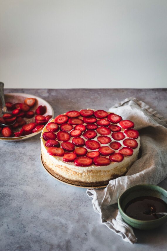 Sliced strawberries on top of a cheesecake.
